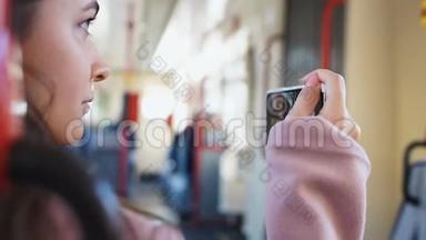 女孩在乘公共汽车旅行时用电话拍摄城市，现场直播，旅行博客